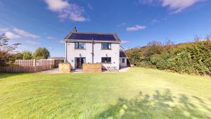 a white house with a solar roof on a yard at Low Greenlands Holiday Park - Luxury House & Luxury Glamping Pods in Lancaster