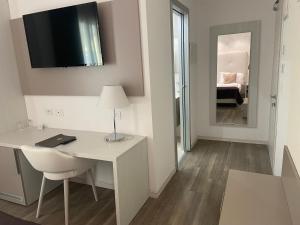 a room with a desk with a lamp and a mirror at International Beach Hotel in Caorle