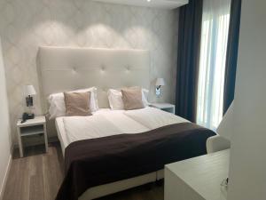a bedroom with a large bed with a large headboard at International Beach Hotel in Caorle