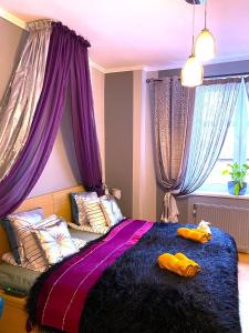 um quarto com cortinas roxas e uma cama grande em Silwer ROOM em Cracóvia