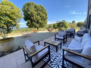 a patio with couches and chairs and a table at Aux Coteaux d'Aussac in L Honor De Cos