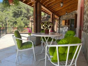 patio ze stołem i krzesłami na ganku w obiekcie VILLA AURA by AgroHolidays w mieście Platres