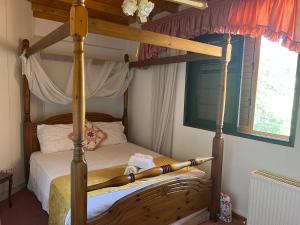 a bedroom with a four poster canopy bed at VILLA AURA by AgroHolidays in Platres