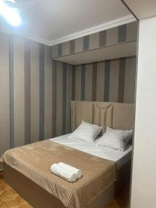 a bed with two towels on top of it at Apartment George in Kutaisi