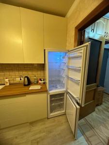 a refrigerator with its door open in a kitchen at Apartment George in Kutaisi
