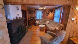 ein Wohnzimmer mit einem Sofa und einem Kamin in der Unterkunft WROTA PODLASIE in Siemiatycze