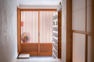 直島町にあるNaoshima Juju Art House　直島ジュジュアートハウスの窓付きの木製ドアのある廊下