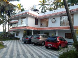 Somatheertham Ayurvedic Resort في تريفاندروم: ثلاث سيارات تقف امام مبنى