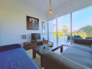 ein Wohnzimmer mit 2 Sofas und einem TV in der Unterkunft STAY Coralli Apartment in Protaras