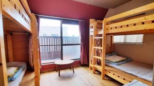 a room with two bunk beds and a window at Guesthouse Yours in Osaka