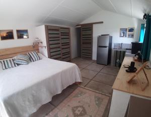 a bedroom with a large white bed and a kitchen at Kailani in Calodyne