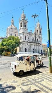 Un autobus bianco che guida lungo una strada di fronte a una chiesa di Beautiful apartment In historic center a Lisbona