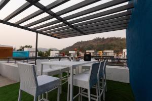 Denver Villa في لونافالا: طاولة بيضاء وكراسي على السطح