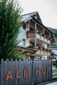 ein Haus hinter einem Zaun mit einem heißen Schild in der Unterkunft ALMHOF Alpin Apartments & Spa in Dienten am Hochkönig