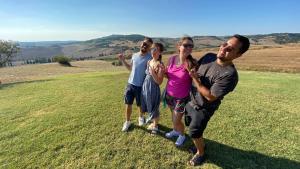 a group of people standing on top of a field at Agriturismo Barbi in Monticchiello