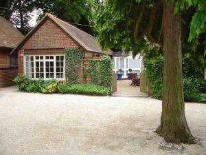 una casa de ladrillo con un árbol delante de ella en Oxfordshire Country Cottage, en Wallingford
