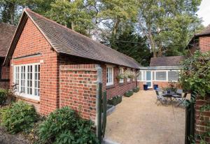 a brick house with a fence and a patio at Oxfordshire Country Cottage in Wallingford