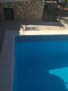 a blue swimming pool with a sign on the side of it at Deni in Sevid