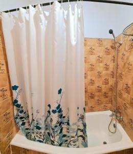 a shower curtain with a flower pattern on it in a bathroom at Station House in Braga