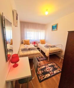 Una pequeña habitación con dos camas y una mesa. en Station House, en Braga