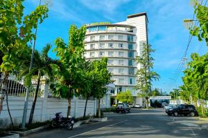 a hotel on a street with cars parked in front of it at Hoa Binh 1 Hotel in Long Xuyên