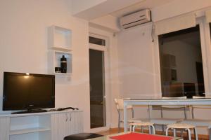 a living room with a television and a table with chairs at Panoramic View Skopje Apartments in Skopje