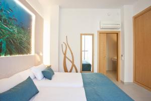 a bedroom with a bed with a painting on the wall at Apartaments Posidonia in Colonia Sant Jordi +46 photos