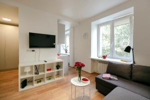 ein Wohnzimmer mit einem Sofa und einem TV in der Unterkunft Jana Pawła II 36 - Bezpłatny podziemny garaż - Free Parking - W pełni wyposażone studio - Better Rental in Warschau