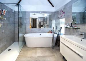 een badkamer met een bad, een wastafel en een douche bij Hazelbank, Kingswear in Kingswear