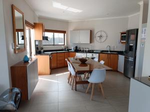 a kitchen with a table and chairs and a kitchen with at Sunset Villa in Langebaan