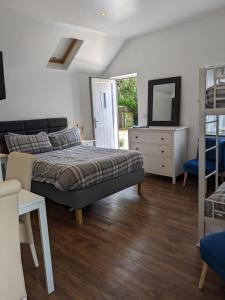 1 dormitorio con cama, tocador y espejo en Featherbed Cottage, en Coventry