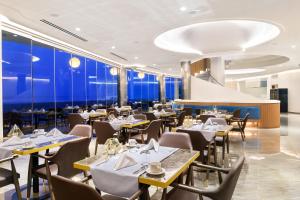 un restaurante con mesas, sillas y paredes azules en Alexandra Elegance Bridging Generations, en Potos