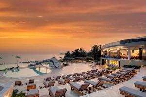 een resort met een zwembad en stoelen en een glijbaan bij Alexandra Elegance Bridging Generations in Potos