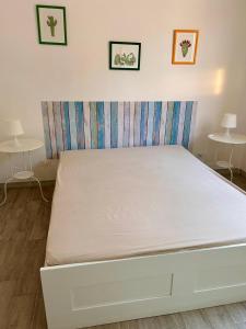 a white bed in a room with two tables at Villa Giulia in Portopalo