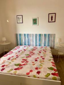 a bed with a floral quilt on it in a bedroom at Villa Giulia in Portopalo
