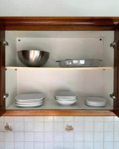 a cupboard with plates and bowls in a kitchen at Casa di Giorgio in Nafpaktos