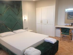 1 dormitorio con cama blanca y pared verde en Gurtas Hotel, en Antalya