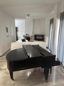 um piano preto sentado numa sala com uma cama em Casa di Giorgio em Lepanto