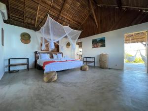 a bedroom with a bed with a net at Canopee Lodge in Nosy Komba