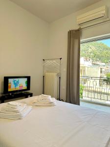 a bedroom with a bed with a tv and a window at Casa di Giorgio in Nafpaktos