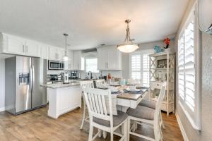 een keuken met witte kasten en een tafel met stoelen bij Surfside Beach Home with Hot Tub Walk to Beach! in Surfside Beach