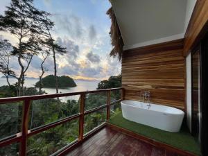a bath tub on a balcony with a view of the ocean at 89 Villas in El Nido