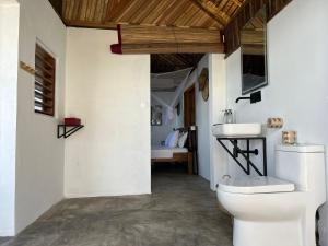 a bathroom with a white toilet and a sink at Canopee Lodge in Nosy Komba