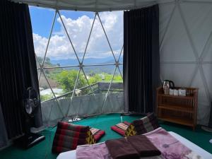 a room with two beds and a large window at Phu Fahsai Homestay in Mon Jam