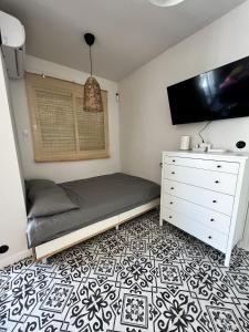 sypialnia z łóżkiem, telewizorem i komodą w obiekcie Cozy apartment La Mata w mieście La Mata