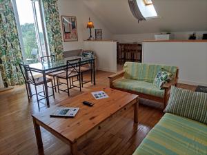 uma sala de estar com um sofá, uma mesa e cadeiras em Villas du Lac em Clairvaux-les-Lacs
