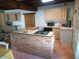 una cucina con un'isola di mattoni al centro di Charmante maison en pierres a Sainte-Radégonde-des-Noyers Altre 2 foto