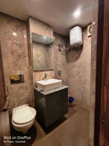 a bathroom with a white toilet and a sink at Hotel Green Valley in Guwahati