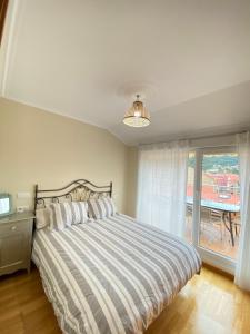 a bedroom with a large bed and a balcony at Apartamento en el centro de Cedeira nuevo y con terraza in Cedeira