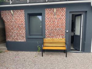 un banc en bois assis devant un bâtiment dans l'établissement Charmant T2 à Lezennes, à Lezennes